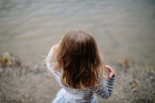 Enfant au bord de l'eau avec cheveux détachés