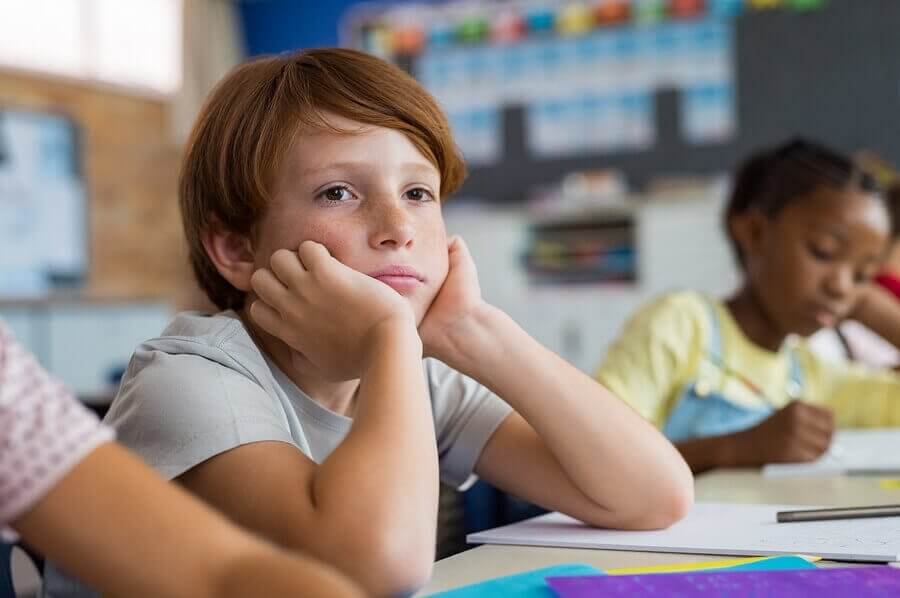 Un élève songeur en classe.