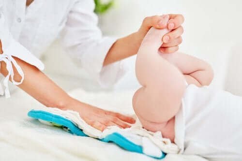 Une femme en train de changer la couche du bébé.