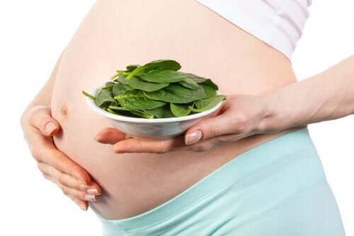 Une femme enceinte mange des salades