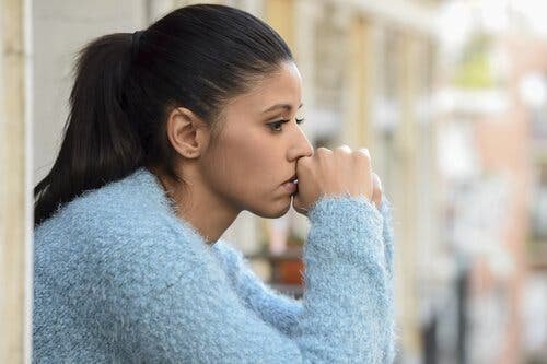 Une femme inquiète, ressentant les effets du stress sur son corps.