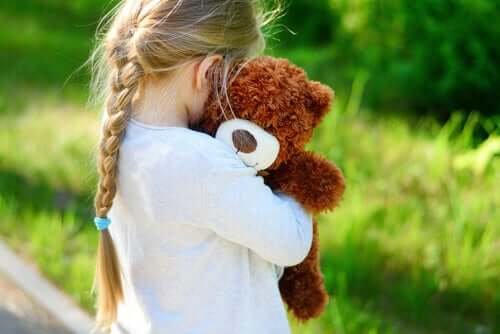 Une fille tenant son ours en peluche