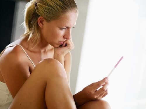Une femme regardant un test de grossesse.