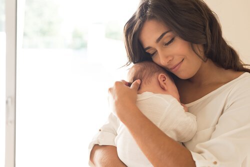 Une mère et son bébé dans les bras.