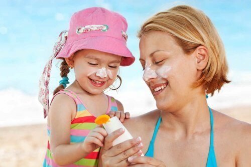 Mère et fille mettant de la crème solaire