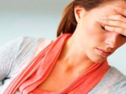 Une femme se tenant le visage, illustrant le stress émotionnel